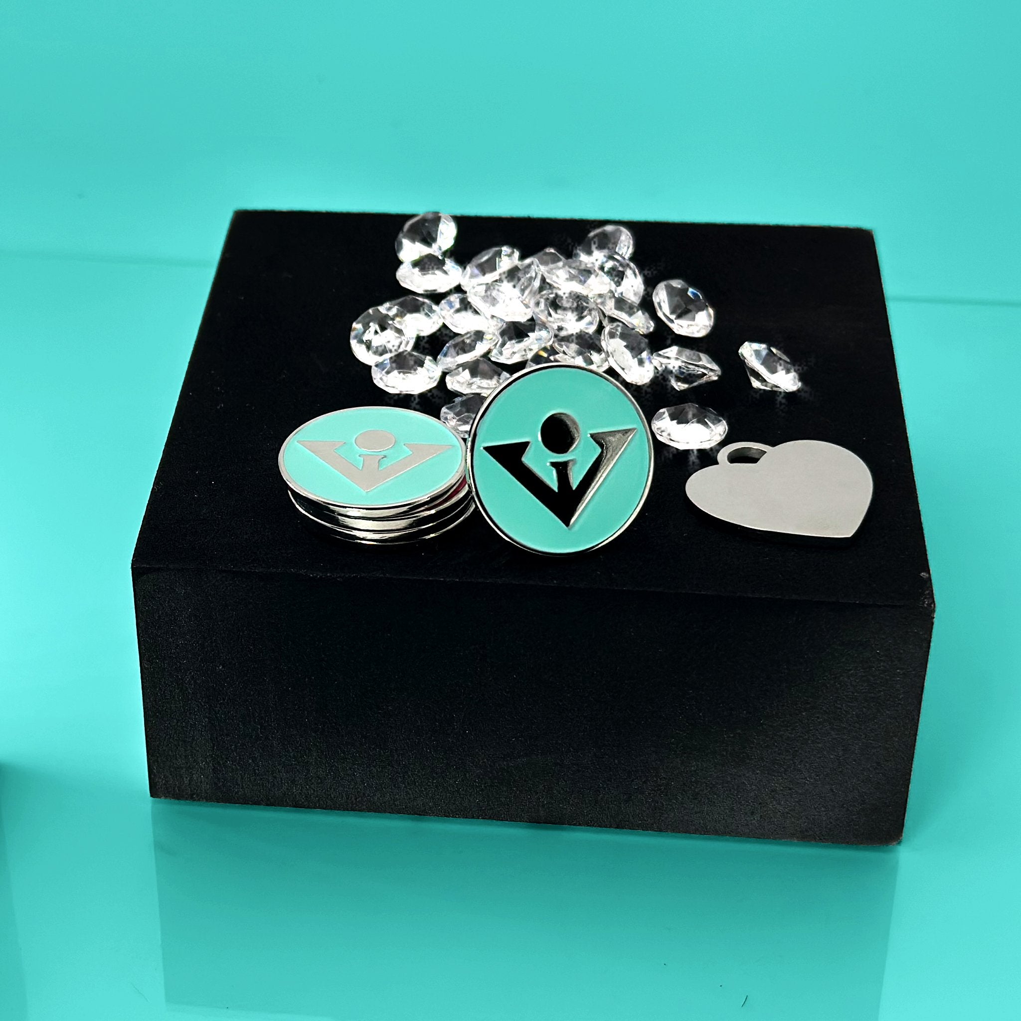 Ball marker in Tiffany blue next to heart pendant and diamonds, made for our magnetic golf gloves.