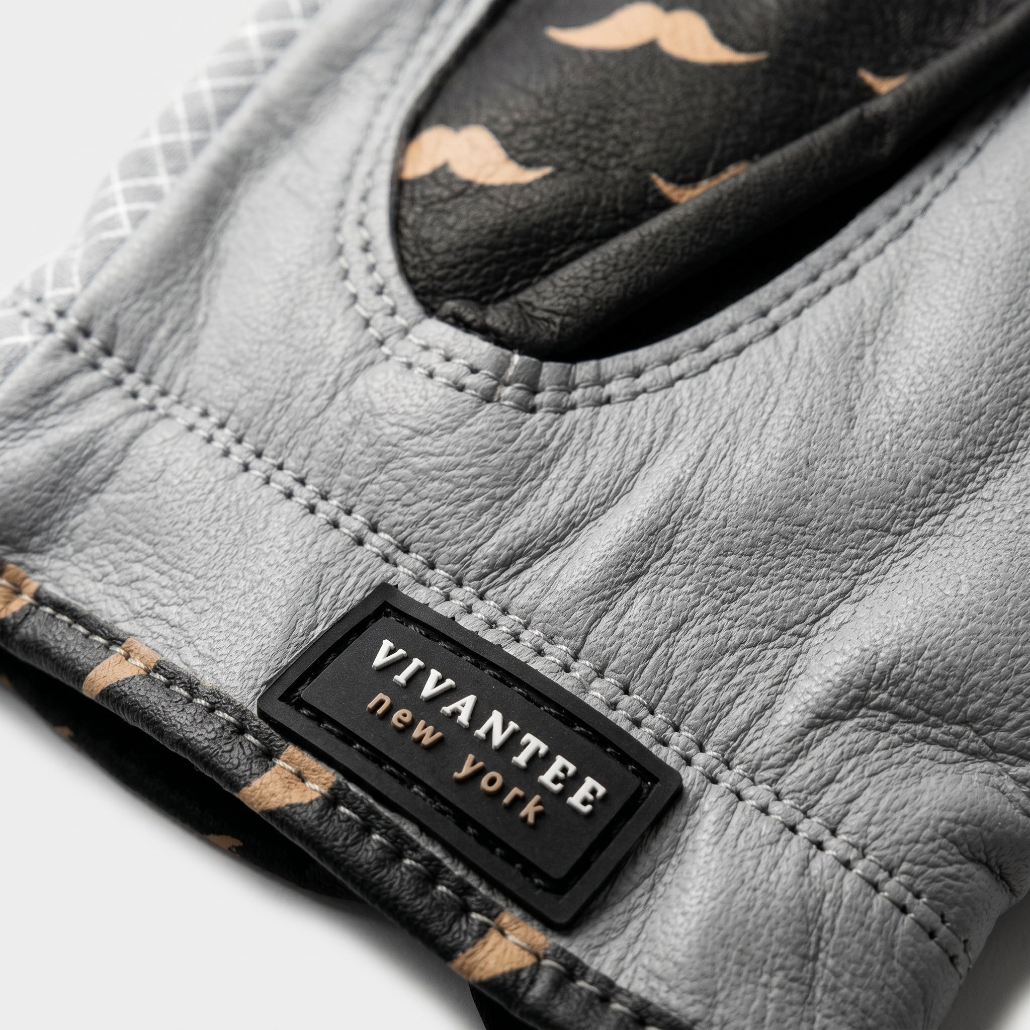 Gray leather glove with a 'Vivantee New York' label on a light gray background