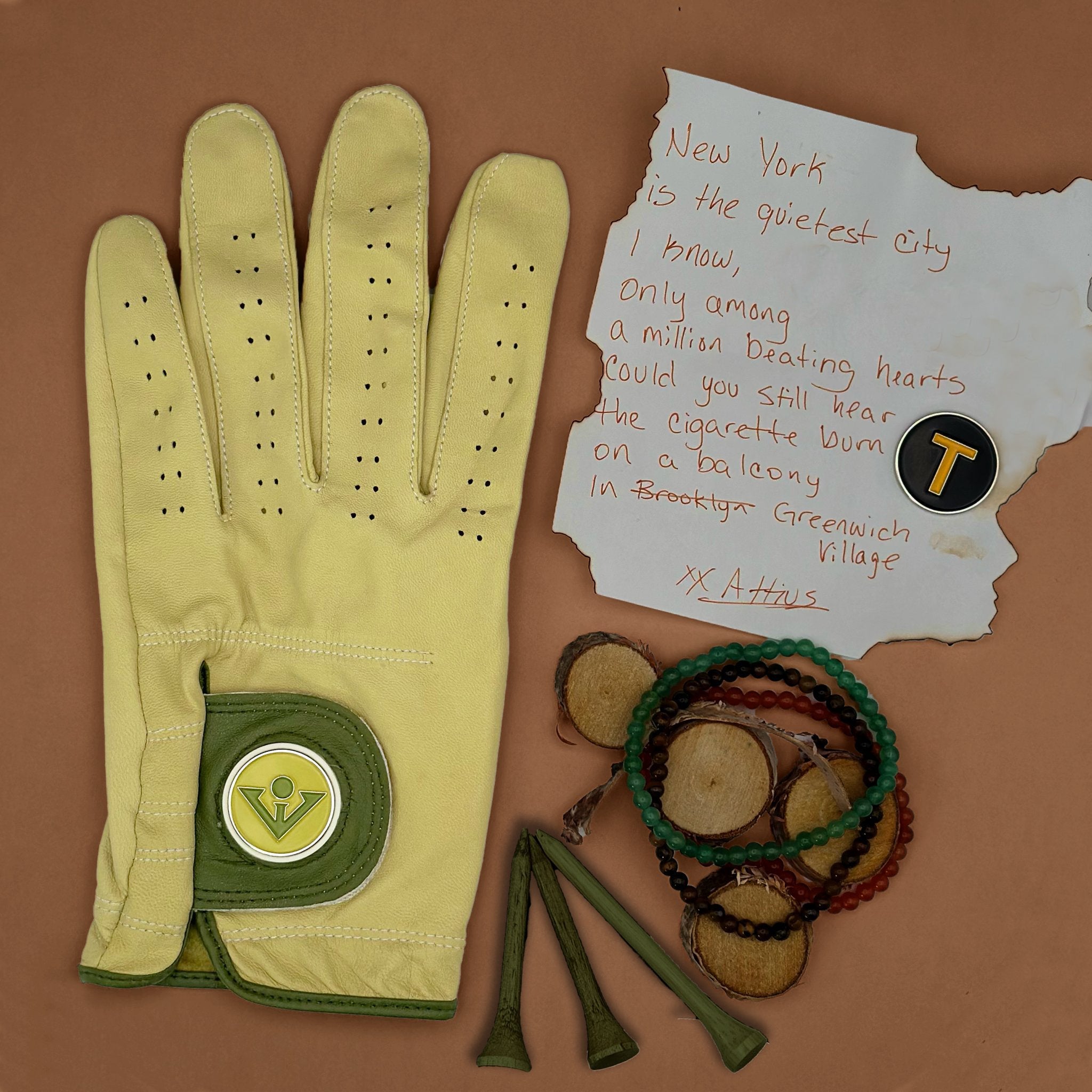 Yellow and Green golf glove surrounded by earthy tones, wood, and a poem to represent Greenwich Village's Bohemian Style.