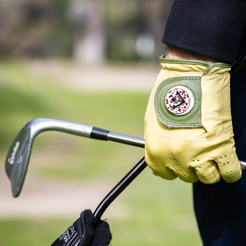 Mustard Yellow and Olive Green Golf Glove with Magnetic ball marker with black and white backdrop.