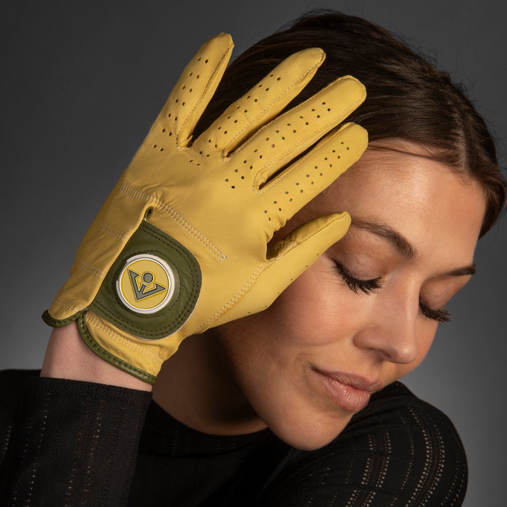 Women's Yellow and Olive Green golf glove by VivanTee in front of model as she is posing with the glove in front of her face.