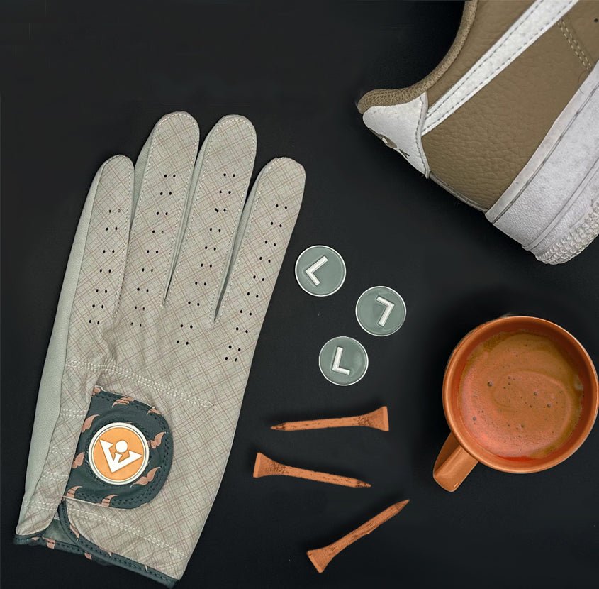Golf glove with magnetic ball marker next to tees, a coffee, and Nike shoes to represent the NYC inspiration of the design.