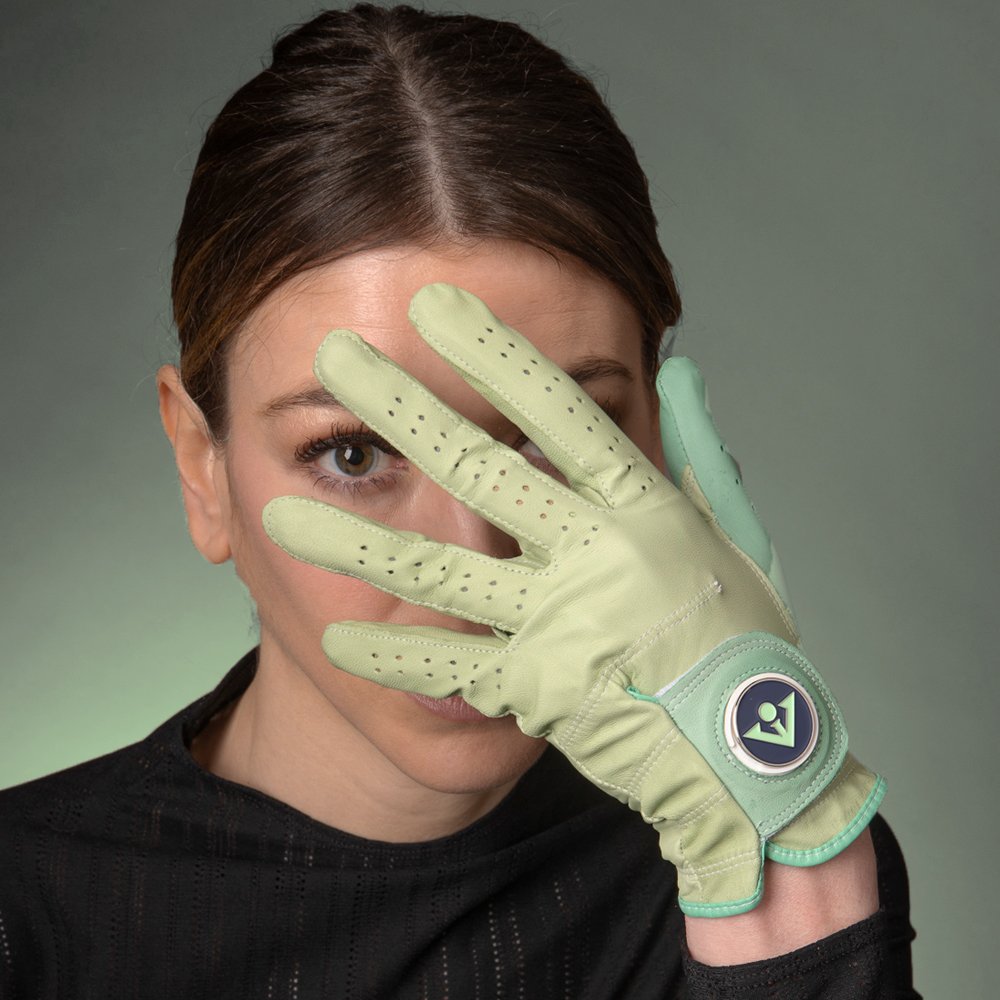 Women's Seafoam green golf glove by VivanTee golf with model holding glove across her face in a dim green background showing unique colors.