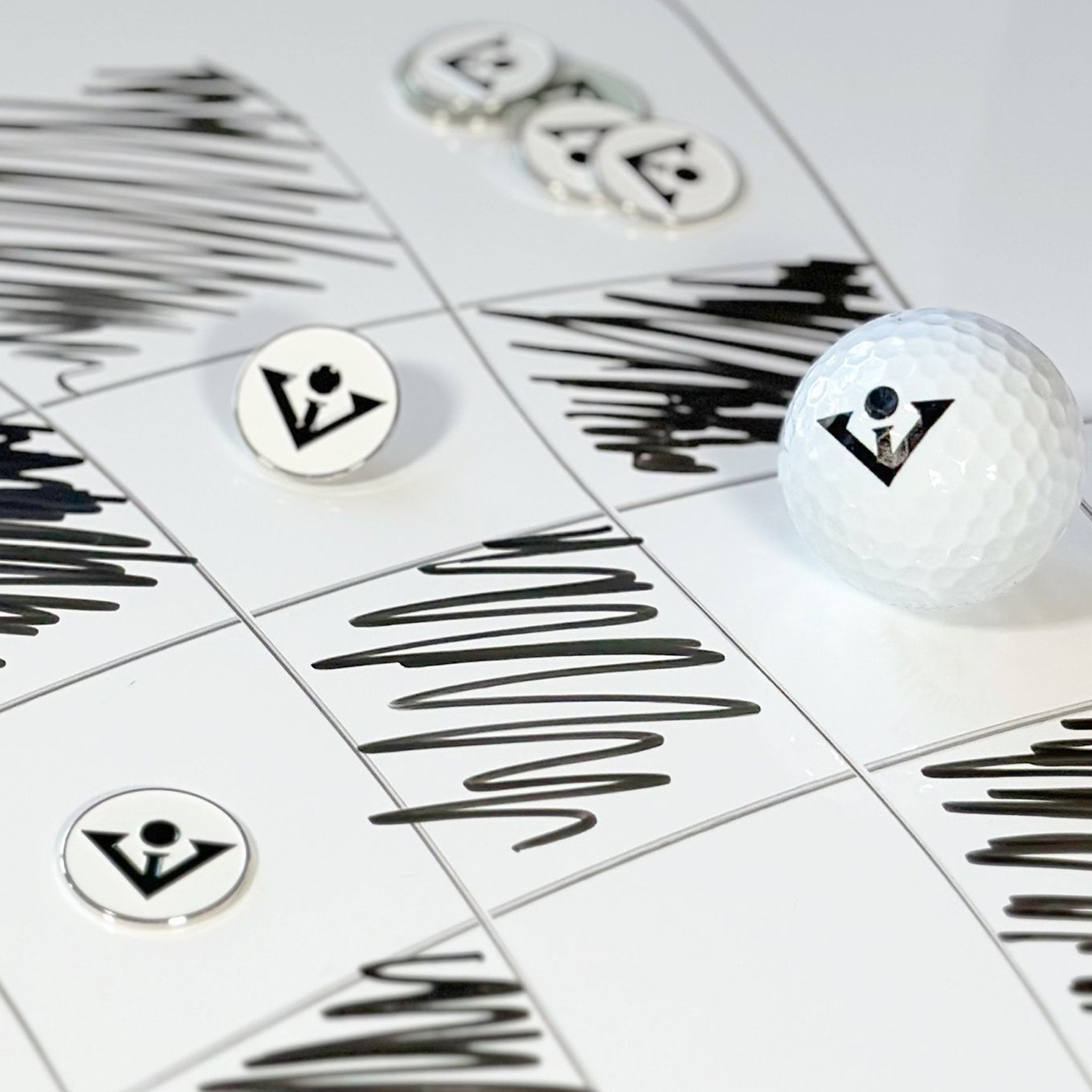 Black and white magnetic golf ball marker for our golf gloves with ball markers with a black and white checkered backdrop.